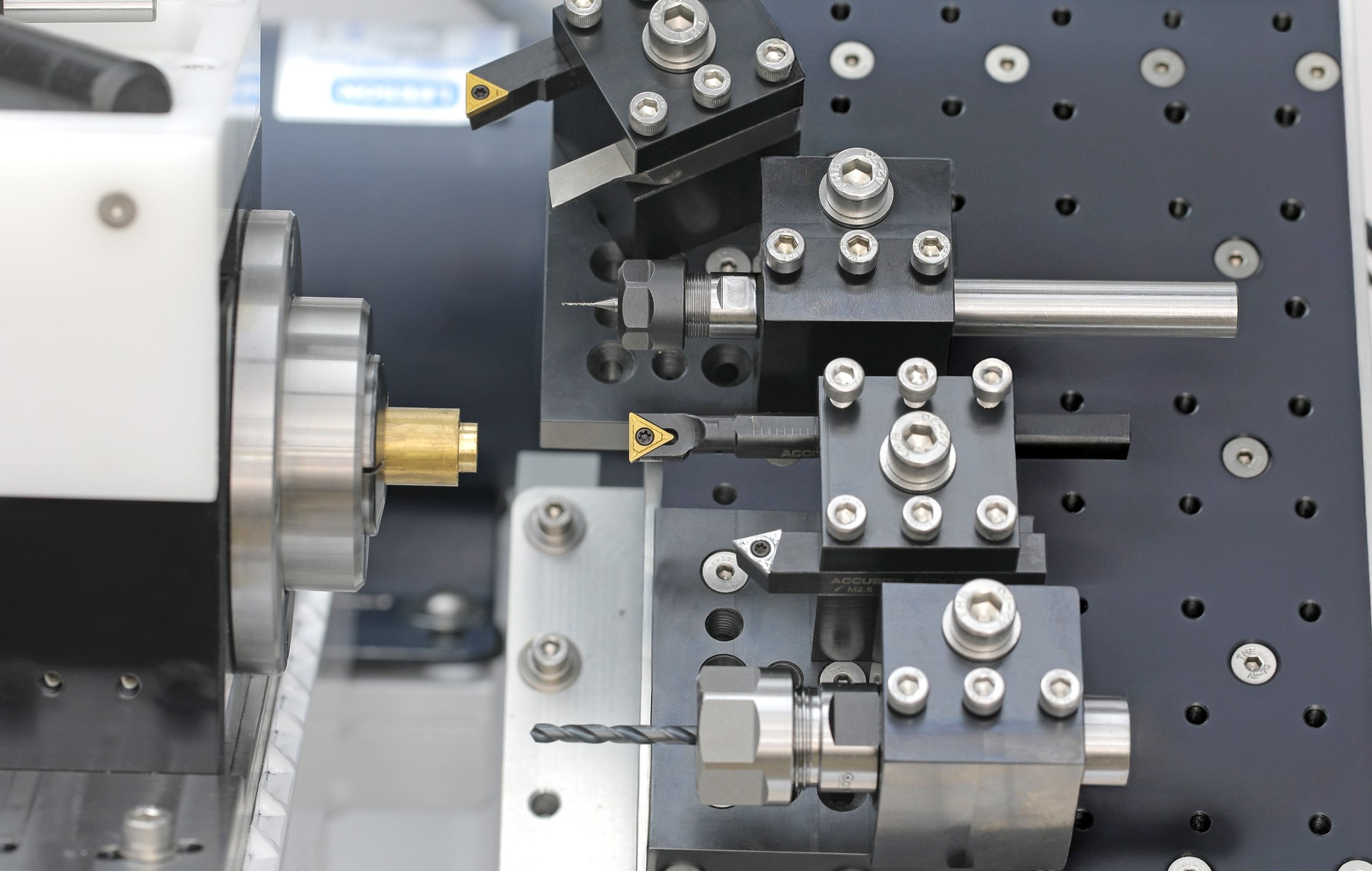 The Lathe 3 gang plate loaded with tools: turning tools, drill holders, and a boring bar staged in a row next to the spindle